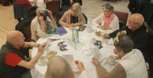 players at a round table examine notes